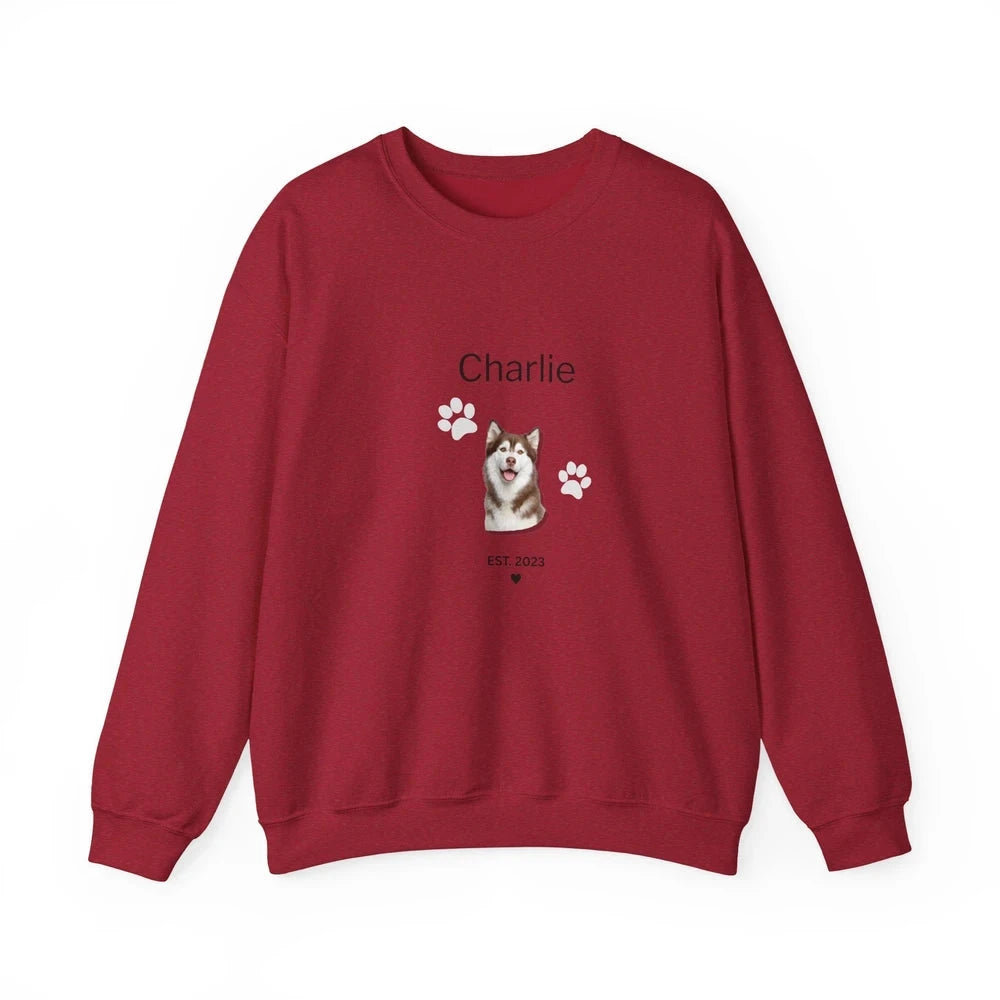 A red crewneck sweatshirt featuring a custom graphic of a husky dog with the name 'Charlie' and paw prints on the front, displayed against a solid white background.