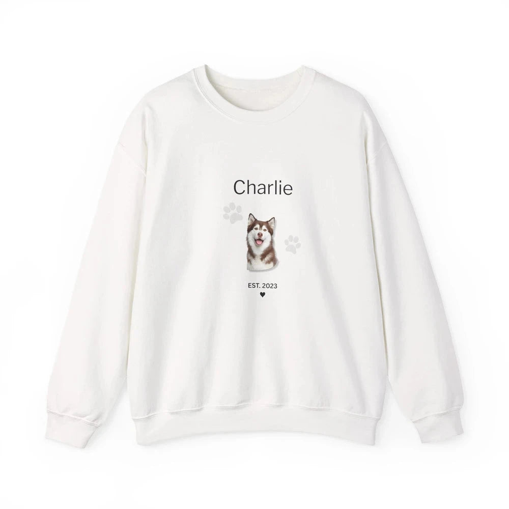 An off-white crewneck sweatshirt featuring a custom graphic print of a Husky dog named 'Charlie' with paw prints and 'EST. 2023' text on the front, displayed against a clean white background.