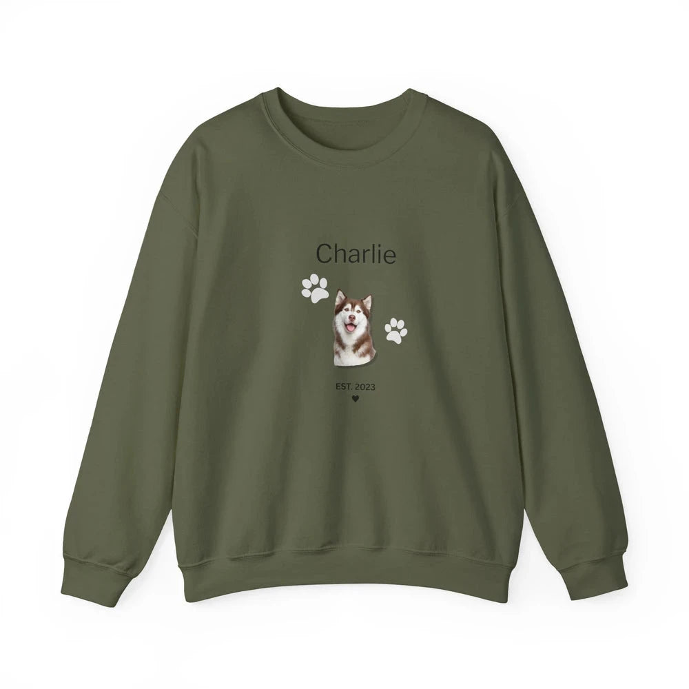An olive green crewneck sweatshirt featuring a custom graphic of a husky dog, paw prints, and the name 'Charlie' printed on the chest, displayed against a plain white background.